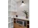 Modern pantry with white shelving and built-in microwave at 7 1 St Ct, Windermere, FL 34786