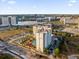 Stunning aerial view of a condo complex with a pool, lush landscaping, and a lake in the background at 7383 Universal Blvd # 207, Orlando, FL 32819
