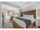 Spacious bedroom with two beds, a wood accent wall, and a view of the neighborhood at 7383 Universal Blvd # 207, Orlando, FL 32819