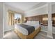 Bright bedroom featuring a king bed, wood headboard, and a large window with scenic views at 7383 Universal Blvd # 207, Orlando, FL 32819