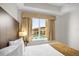 Cozy bedroom featuring a comfortable bed, a window with a pool view, and tasteful decor at 7383 Universal Blvd # 207, Orlando, FL 32819
