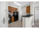 Well-equipped kitchen features sleek black appliances and wooden cabinetry at 7383 Universal Blvd # 207, Orlando, FL 32819