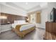 Comfortable bedroom featuring a tray ceiling, a wood accent wall, and a large window at 7383 Universal Blvd # 207, Orlando, FL 32819