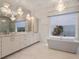 Luxurious bathroom featuring a soaking tub, double vanity, and chandelier at 900 Jack Nicklaus Ct, Kissimmee, FL 34747