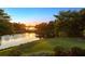 Scenic sunset view over tranquil lake with lush landscaping at 9138 Great Heron Cir, Orlando, FL 32836