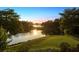 Scenic sunset view over tranquil lake with lush landscaping at 9138 Great Heron Cir, Orlando, FL 32836