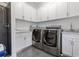 Modern laundry room with white cabinets, washer, dryer, and granite countertops at 9138 Great Heron Cir, Orlando, FL 32836