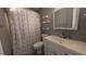 Clean bathroom with a white vanity and geometric shower curtain at 9913 Janette Ln, Clermont, FL 34711