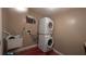 Laundry room with stackable washer and dryer, plus a utility sink at 9913 Janette Ln, Clermont, FL 34711