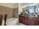 Elegant bathroom with double sinks, granite countertop, and large bathtub at 150 E Robinson St # 3104, Orlando, FL 32801