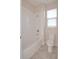Bathroom with white tiled walls, a shower and tub combination, and a window at 169 Magneta Loop, Auburndale, FL 33823