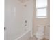 Bathroom with white tiled walls, a shower and tub combination, and a window at 169 Magneta Loop, Auburndale, FL 33823