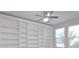 Bright living room featuring built-in bookshelves, a ceiling fan, and large windows with outside views at 169 Magneta Loop, Auburndale, FL 33823