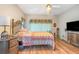 Spacious bedroom with wood floors and an ornate metal bed frame at 17478 Se 115Th Terrace Rd, Summerfield, FL 34491