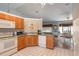 Open kitchen boasts wood cabinets and island overlooking dining area at 17478 Se 115Th Terrace Rd, Summerfield, FL 34491