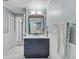 Updated bathroom with navy vanity, white tile, and decorative mirror at 230 W Spring Lake Dr, Altamonte Springs, FL 32714