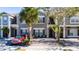 Two-story townhome with gray siding, paver driveway, and palm trees at 2394 Caravelle Cir, Kissimmee, FL 34746
