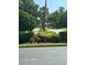 Landscaped entrance to community with paved road and flag at 3000 S Semoran Blvd # S, Orlando, FL 32822