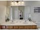 Double vanity bathroom with a large mirror and decorative plants at 334 Orange Cosmos Blvd, Davenport, FL 33837