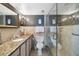 Spacious bathroom with a walk-in shower and granite countertops at 3663 S Atlantic Ave # 11D, New Smyrna Beach, FL 32169