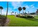 Lush green lawn, palm trees, and ocean views at 3663 S Atlantic Ave # 11D, New Smyrna Beach, FL 32169
