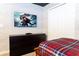 Bedroom with TV, dresser, and plaid bedding at 4355 Scene Ln, Kissimmee, FL 34746