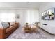 Open living area showcasing a brown leather couch and a large TV at 4355 Scene Ln, Kissimmee, FL 34746