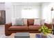 Light-filled living room featuring a brown leather sofa and stylish coffee table at 4355 Scene Ln, Kissimmee, FL 34746