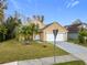 Tan two-story house with a two-car garage and landscaping at 5181 Vista Lago Dr, Orlando, FL 32811