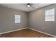 Well-lit bedroom featuring wood-look floors and two windows at 5526 Lily Rd, Lakeland, FL 33811