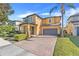 Two-story house with gray door and attached garage, brick paver driveway, and manicured landscaping at 7343 Derexa Dr, Windermere, FL 34786