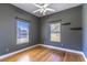 Bedroom with hardwood floors, ceiling fan, and two windows at 8967 Palos Verde Dr, Orlando, FL 32825