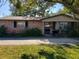 Brick ranch house with a large front yard and a paved walkway at 1002 Charles St, Port Orange, FL 32129