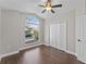 Bright bedroom with arched window, ceiling fan, and dark brown tile floors at 1027 Sweetbrook Way, Orlando, FL 32828