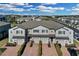 An aerial view showcases the gray two-story townhomes, brick driveways, and landscaping in a well-planned community at 12067 White Wave Pt, Orlando, FL 32828