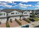 An aerial view showing gray townhomes in a neighborhood, with brick driveways and landscaping under a blue sky at 12067 White Wave Pt, Orlando, FL 32828
