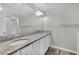 Double vanity bathroom with granite countertop and large mirror at 12067 White Wave Pt, Orlando, FL 32828