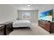 Comfortable bedroom with carpeted floor, large window, and TV at 12067 White Wave Pt, Orlando, FL 32828