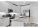 Modern kitchen with white cabinets, granite countertops, and stainless steel appliances at 12067 White Wave Pt, Orlando, FL 32828