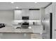 Modern kitchen with white cabinets, granite countertops, and stainless steel appliances at 12067 White Wave Pt, Orlando, FL 32828