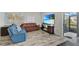Bright living room with hardwood floors, comfortable seating, and large TV at 12067 White Wave Pt, Orlando, FL 32828