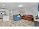 Living room with brown leather and blue couches, wood-look floors at 12067 White Wave Pt, Orlando, FL 32828