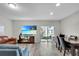 Living room with blue and brown couches, wood-look floors, and patio access at 12067 White Wave Pt, Orlando, FL 32828