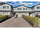 Charming townhomes with brick driveways, attached garages, and well-manicured landscaping under a bright blue sky at 12067 White Wave Pt, Orlando, FL 32828