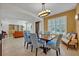 Elegant dining room with a chandelier and a view into the living room at 124 Adler Pt, Oviedo, FL 32765