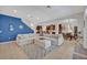 Open living room with sectional sofa, area rug, and view into the kitchen and dining area at 124 Adler Pt, Oviedo, FL 32765