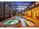 Stunning pool and spa with covered patio at night at 124 Adler Pt, Oviedo, FL 32765
