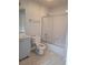 Neat bathroom featuring a shower with sliding glass doors, white tiling, and a gray vanity at 155 N Pearl Lake Cswy # 200, Altamonte Springs, FL 32714