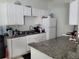White kitchen with granite countertops and appliances at 155 N Pearl Lake Cswy # 200, Altamonte Springs, FL 32714