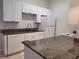 Bright kitchen features white cabinets, granite countertops, and modern appliances at 155 N Pearl Lake Cswy # 200, Altamonte Springs, FL 32714